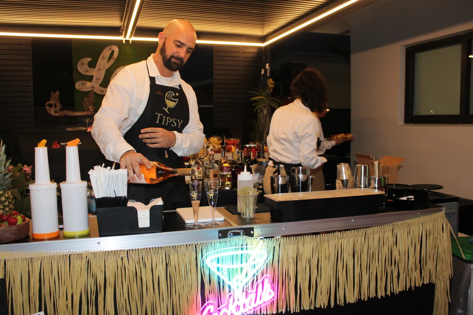 Tipsy Tides bartender working behind the bar at night
