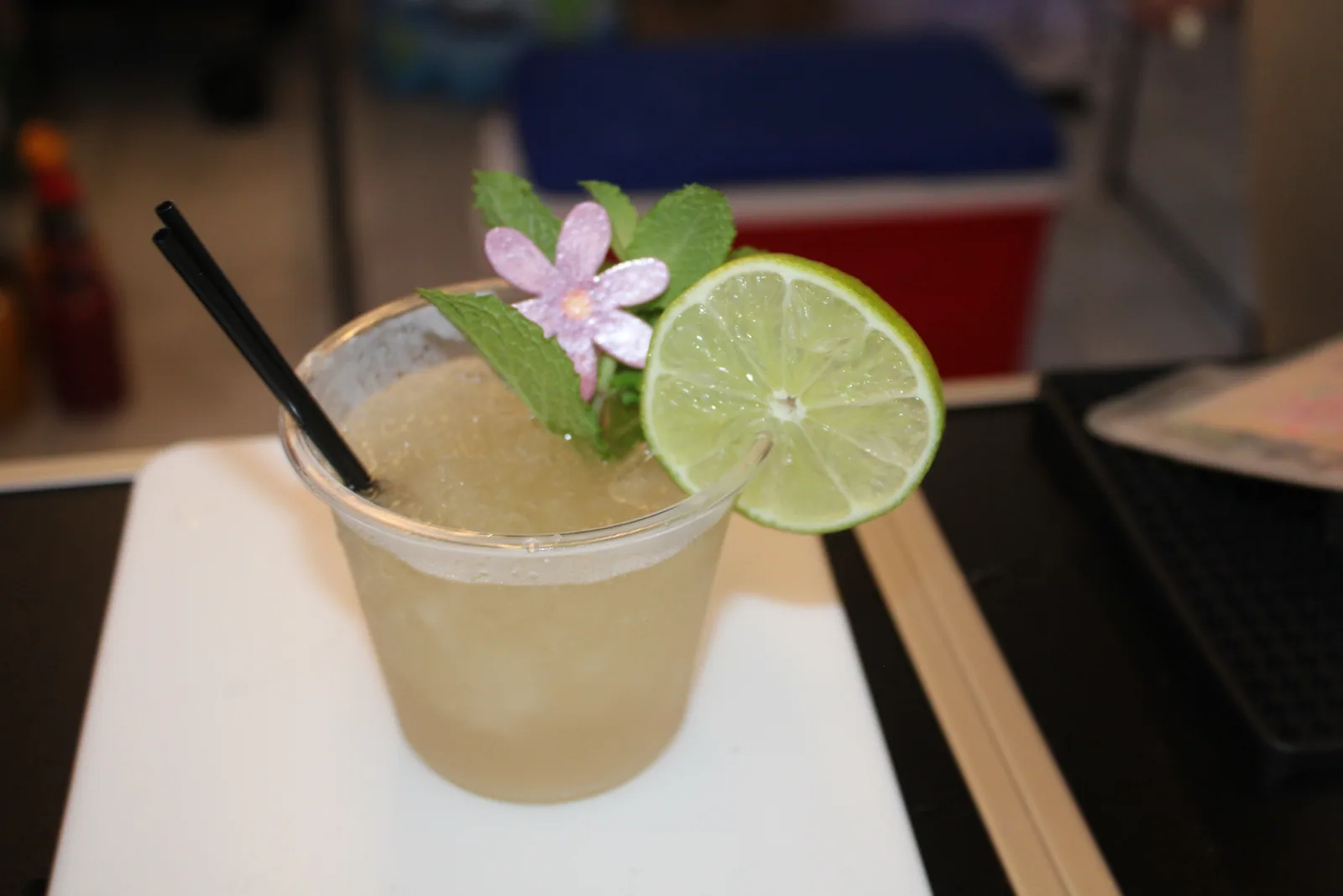 Finished cocktail with lime and edible flower garnish